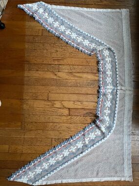 Set of curtain swags, decorated with blue accents and a pink ribbon .